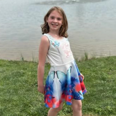 Blue girls’ sundress with butterfly and flower design, “I love you” message, part of Paisley’s Corner Collection, lightweight polyester-spandex blend, ideal for summer and special occasions, girl in butterfly sundress - right side